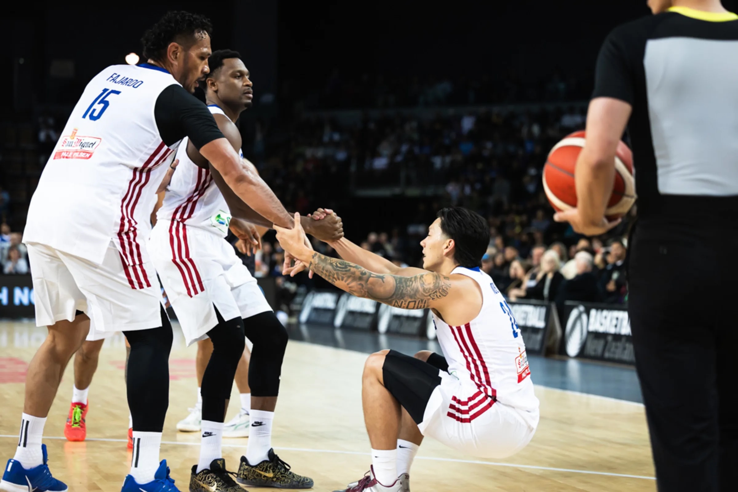 Gilas Pilipinas' Dwight Ramos being helped up by his teammates during a game vs New Zealand in the Fiba World Cup 2027 Asian Qualifiers in Auckland.